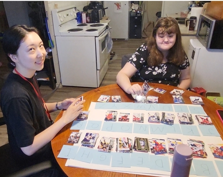 Behavioural Support worker sorting hockey cards with client