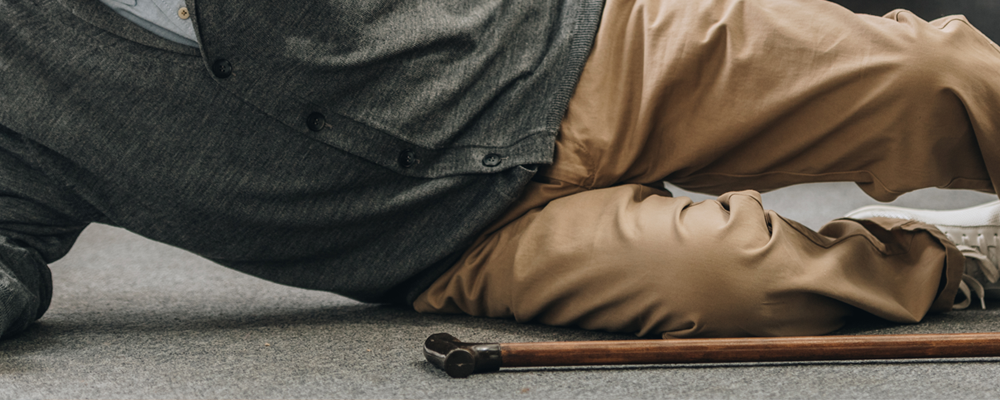 Senior fallen on floor with walking cane in front