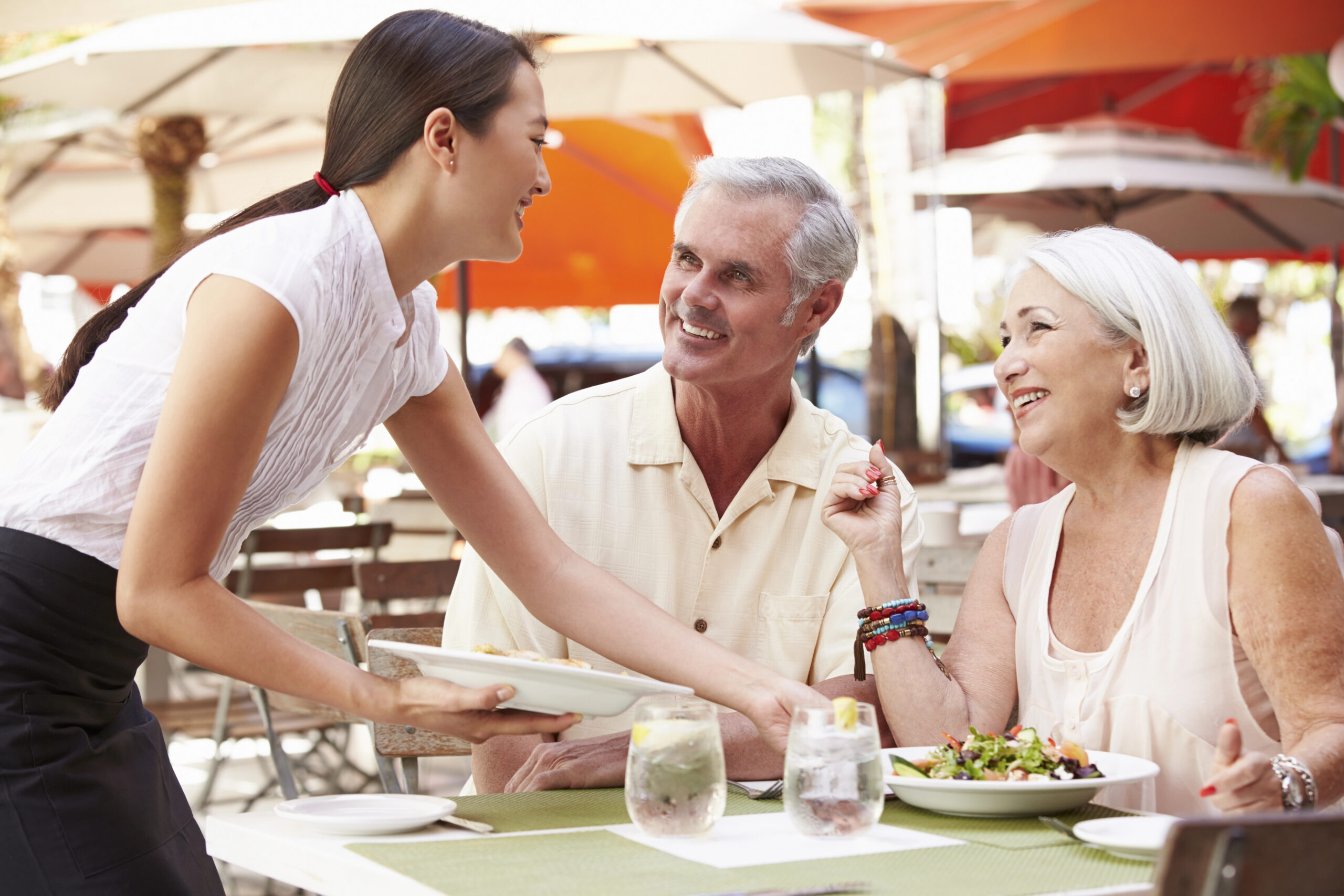 Man and woman smiling at a restaurant server