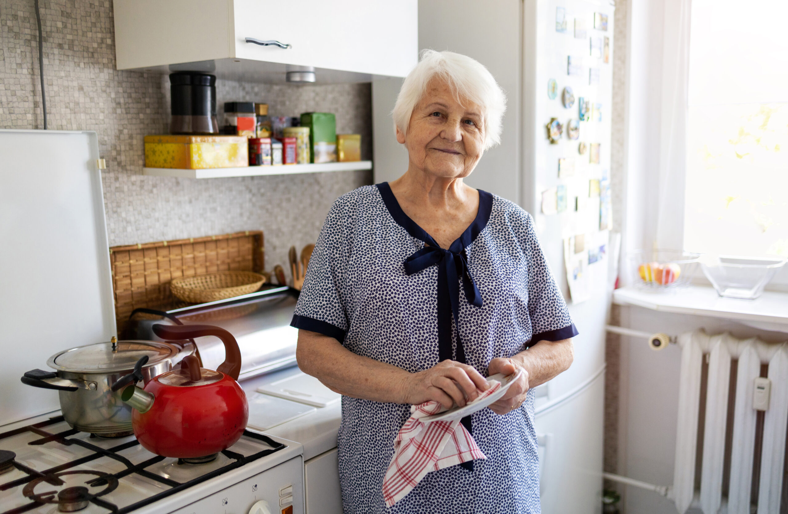 older woman in kitchen by stove